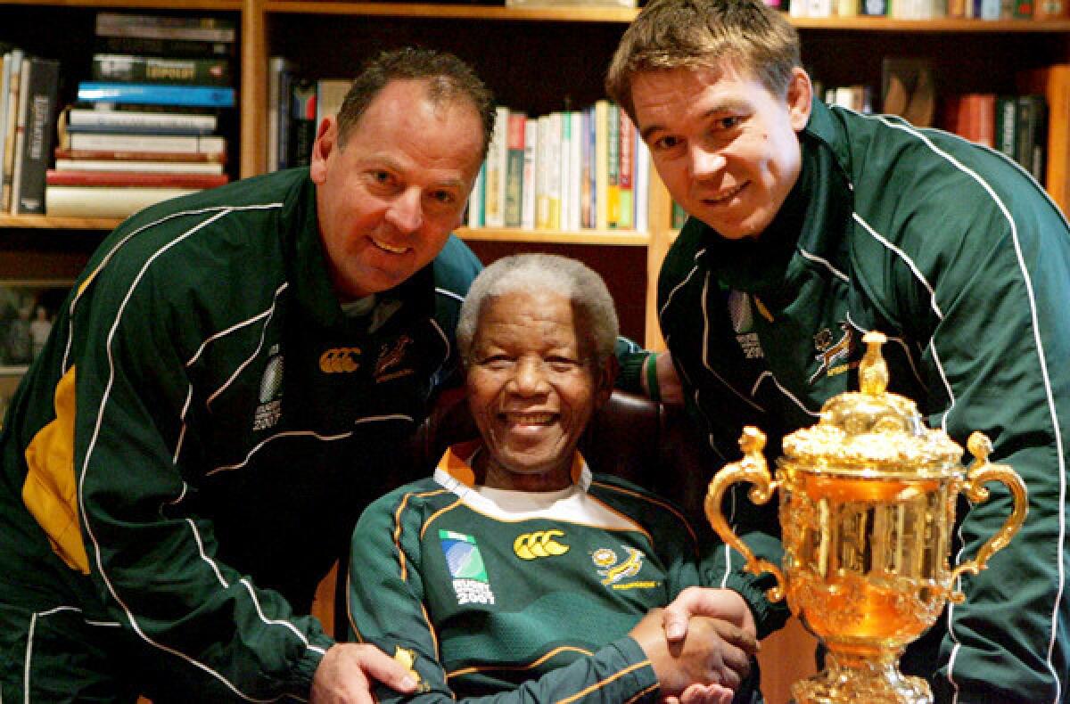 Nelson Mandela poses with South Africa Rugby Union Coach Jake White, left, and captain John Smit after the Springboks won the 2007 World Cup over England.