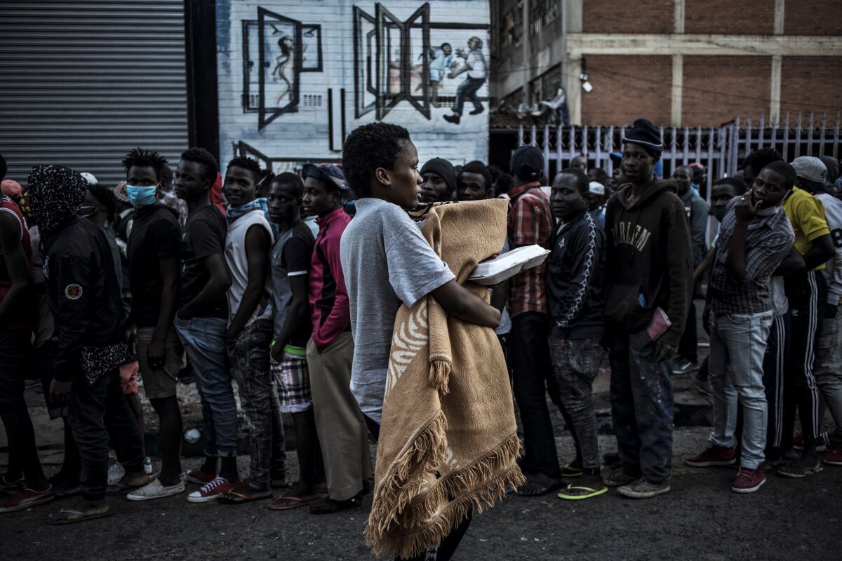 People line up for charity food distribution in Johannesburg, South Africa.
