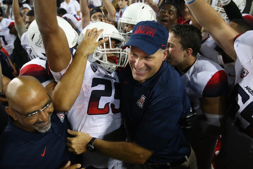 Arizona Coach Rich Rodriguez celebrates with receiver Austin Hill after the Wildcats' 49-45 victory over California on Sept. 20.