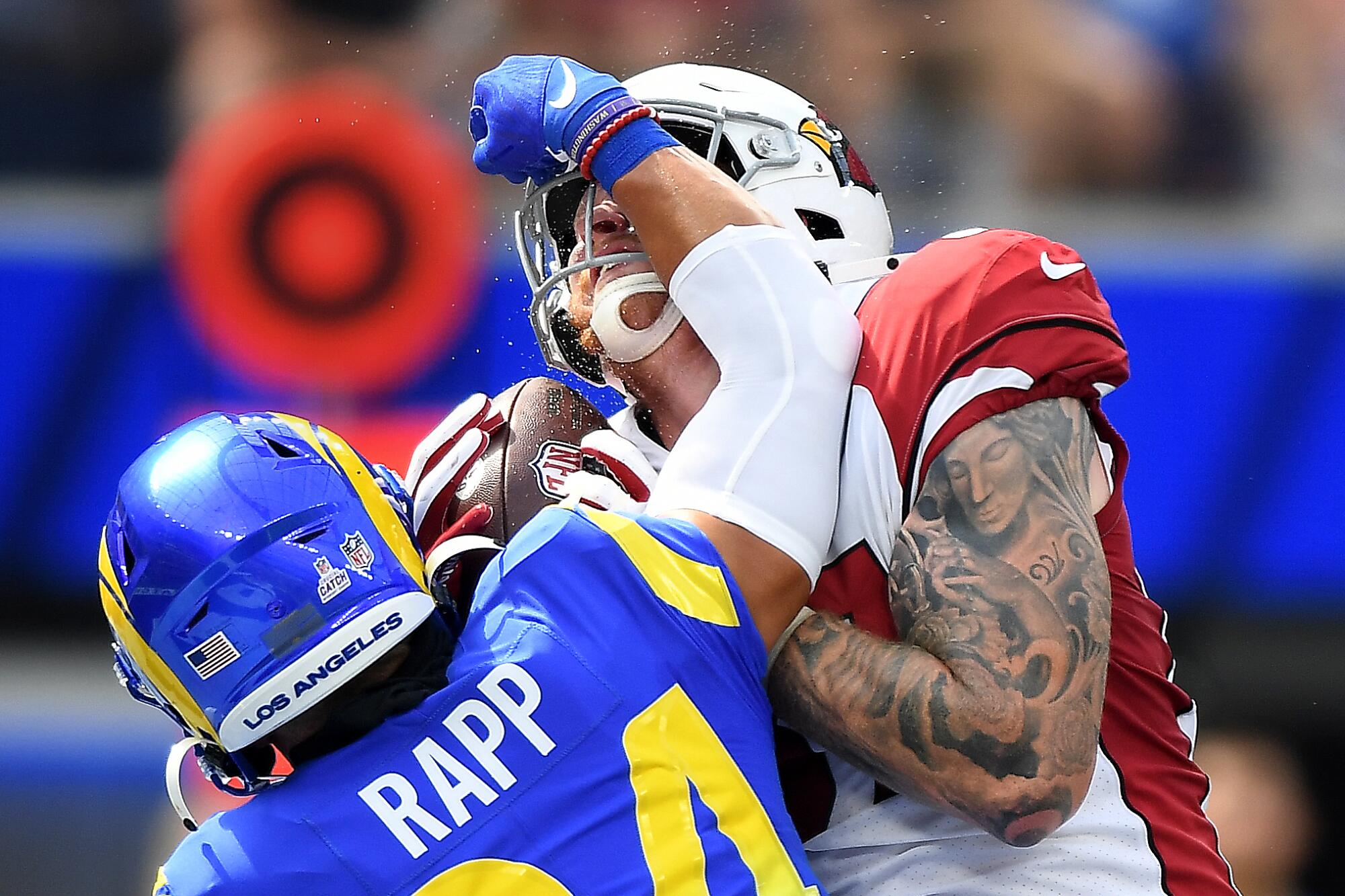 Cardinals tight end Maxi Williams gets hit in the face by Rams safety Taylor Rapp while catching a touchdown pass.