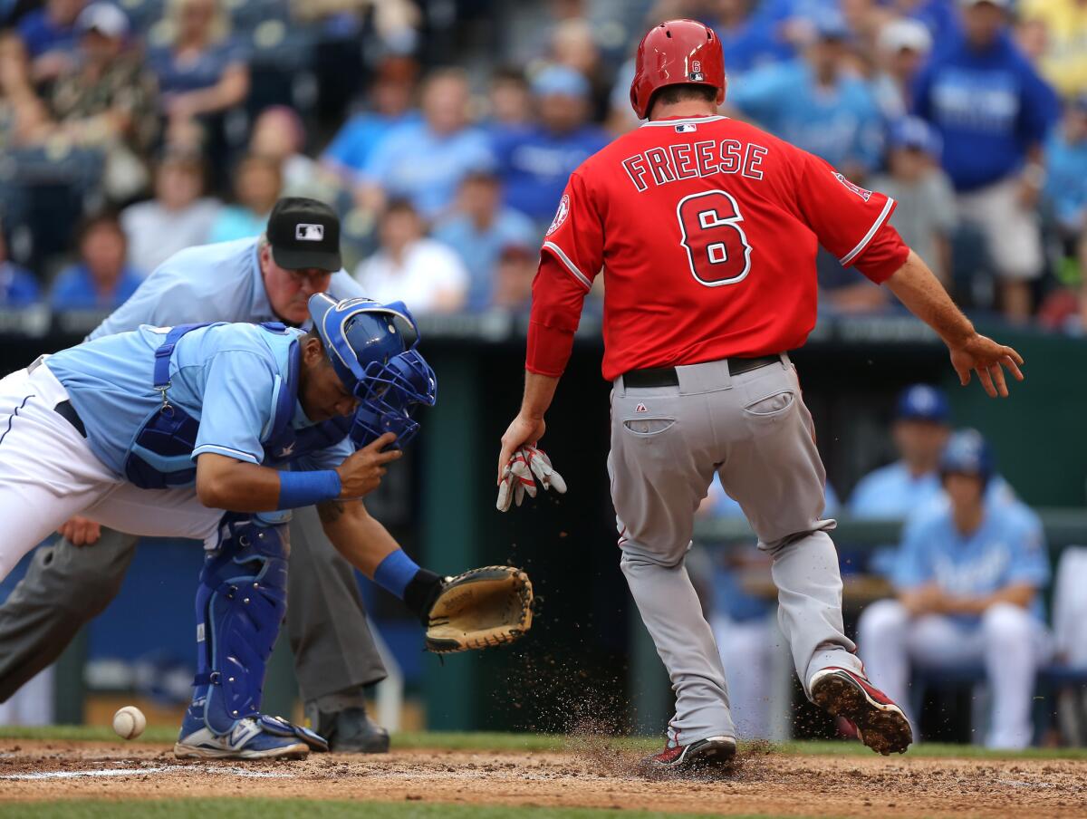 Angels' David Freese crosses home as Kansas City catcher Salvador Perez looks for the ball in the sixth inning Saturday at Kauffman Stadium.