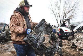 Hunter Cooper helps clean up the Sanchez residence in the snow, Thursday, Feb. 29, 2024, in Canadian, Texas. (AP Photo/David Erickson)