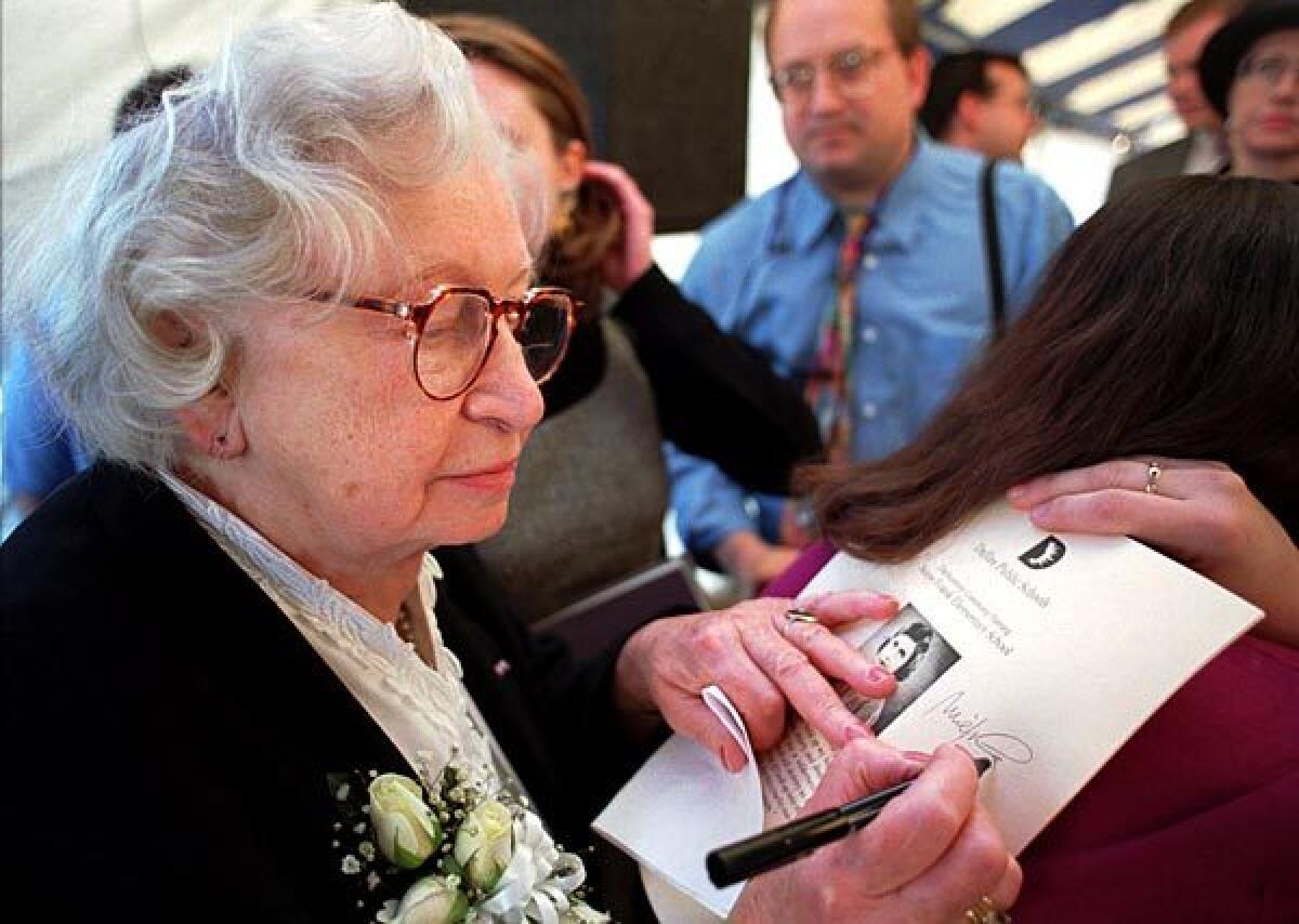 Miep Gies signs a program at the dedication ceremony for Anne Frank Elementary School in Dallas on Nov. 14, 1995.