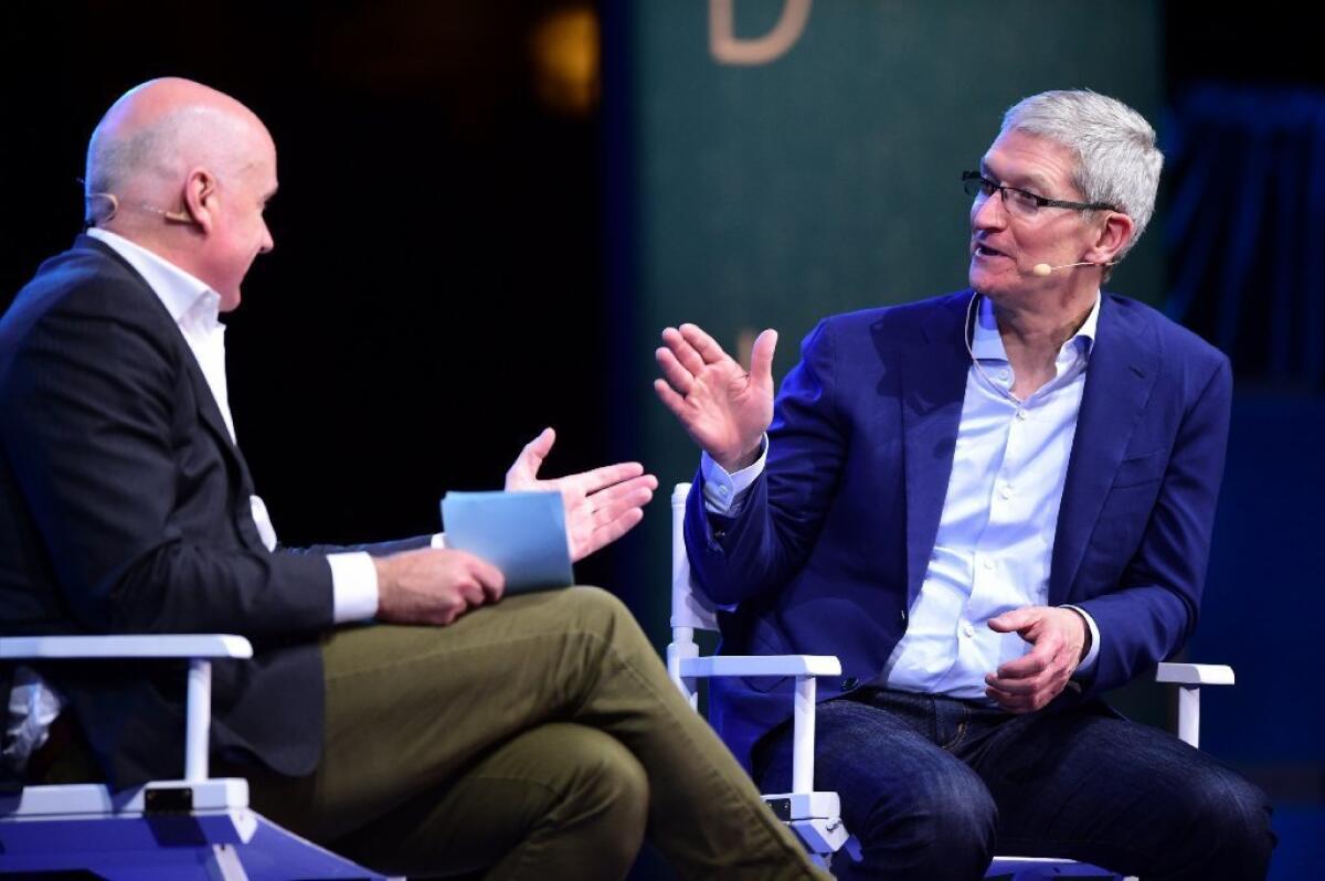 Apple Chief Executive Tim Cook, right, during a Q&A in Laguna Beach on Monday.
