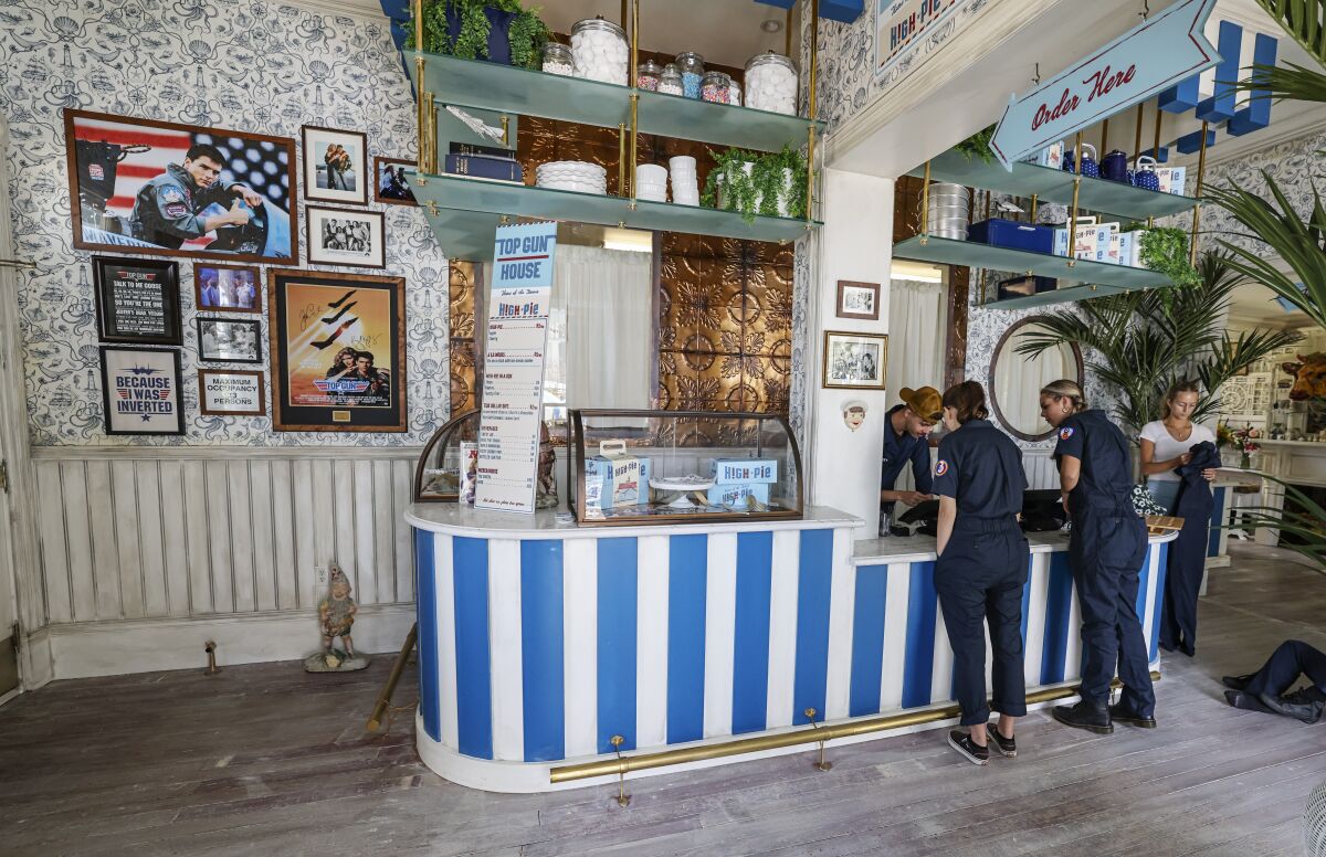 Workers prepare the new pie shop counter in Oceanside's "Top Gun" house.