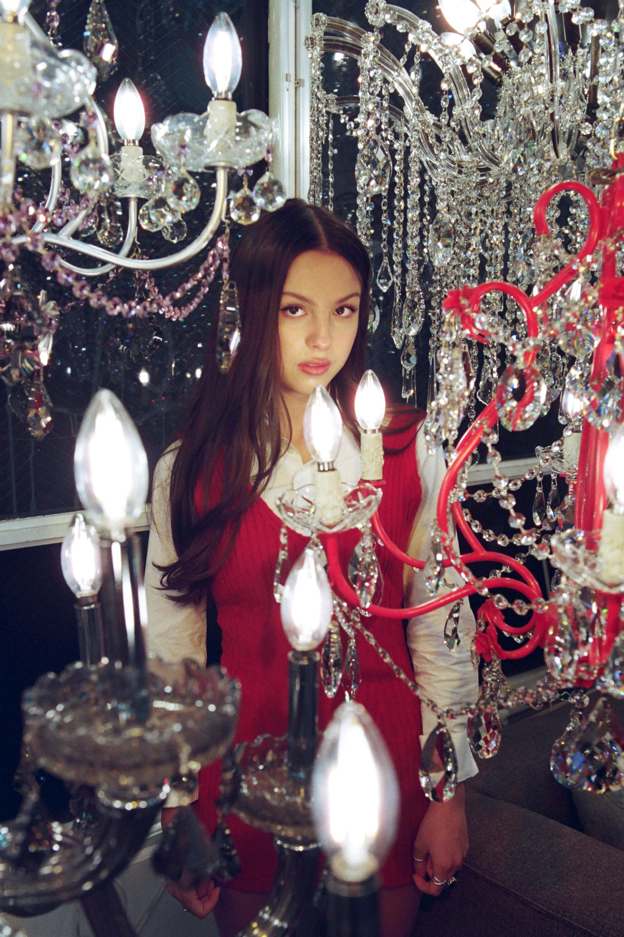 Olivia Rodrigo stands by chandeliers at George's Lighting Plus on Hollywood Blvd.