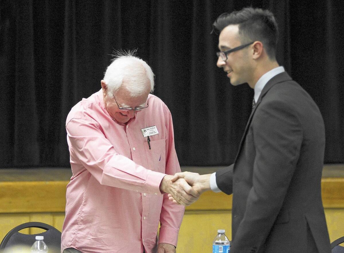 Senior Christian Gray, right, shakes hands with Ken Dufour after group interviews at Back Bay High School on Friday.
