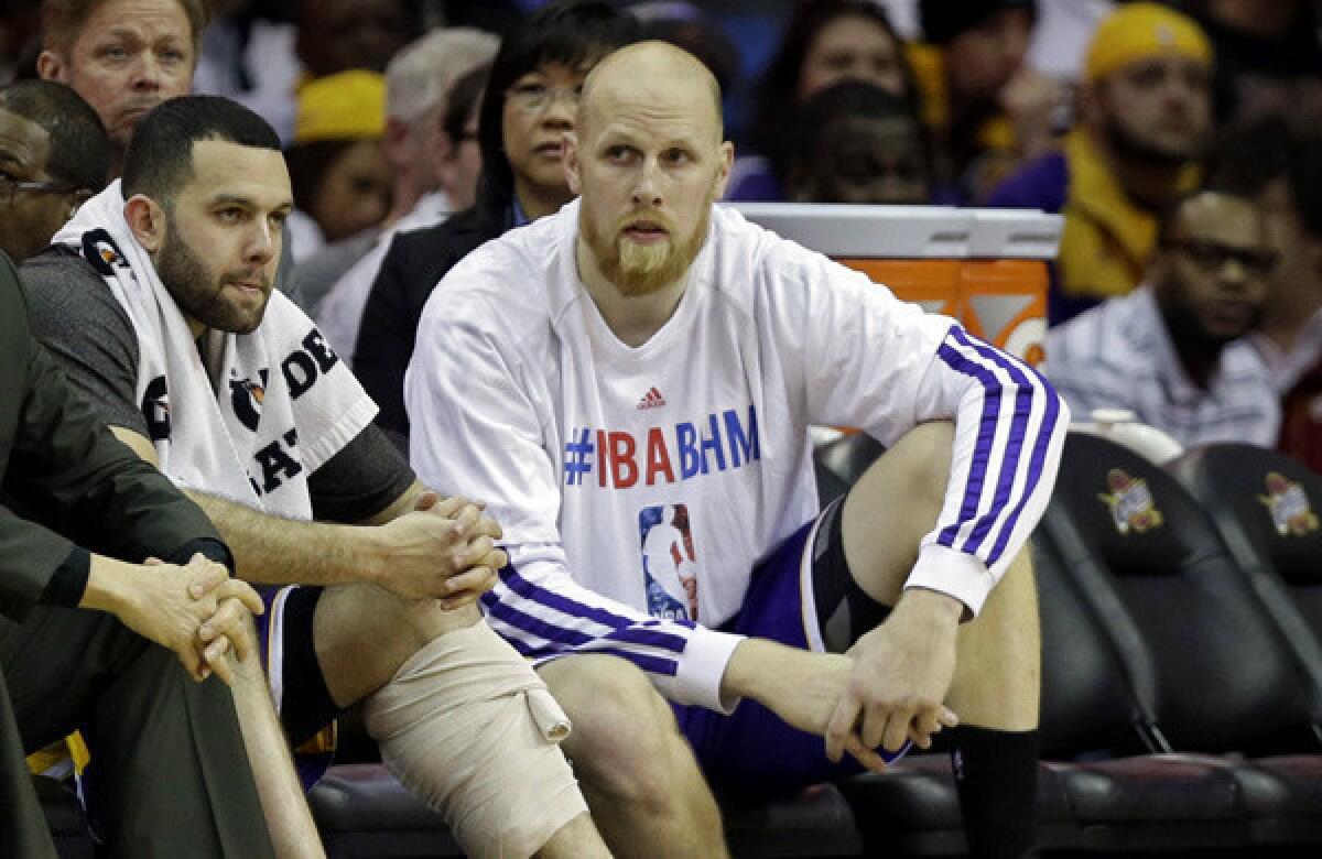 Lakers point guard Jordan Farmar, left, who injured his calf, and center Chris Kaman sit on a nearly empty bench in the fourth quarter Wednesday night in Cleveland.
