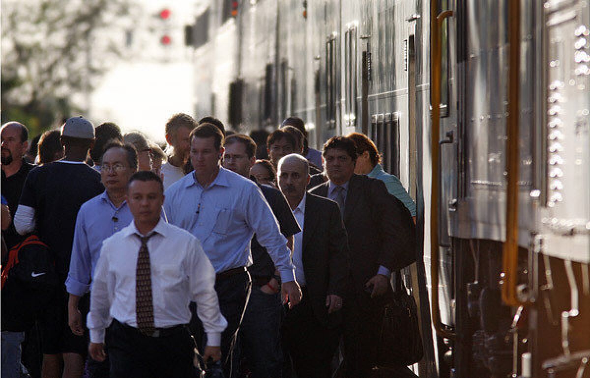 Commuters pour out of a Metrolink train at a busy station just east of Harbor Boulevard in Fullerton.