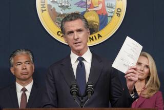 FILE – California Gov. Gavin Newsom displays a state bill signed by him shielding abortion providers and volunteers in California from civil judgments from out-of-state courts during a news conference in Sacramento, Calif., June 24, 2022. Newsom signed nearly 1,000 new laws in 2022. Many of them will take effect on Jan. 1, 2023. (AP Photo/Rich Pedroncelli, File)