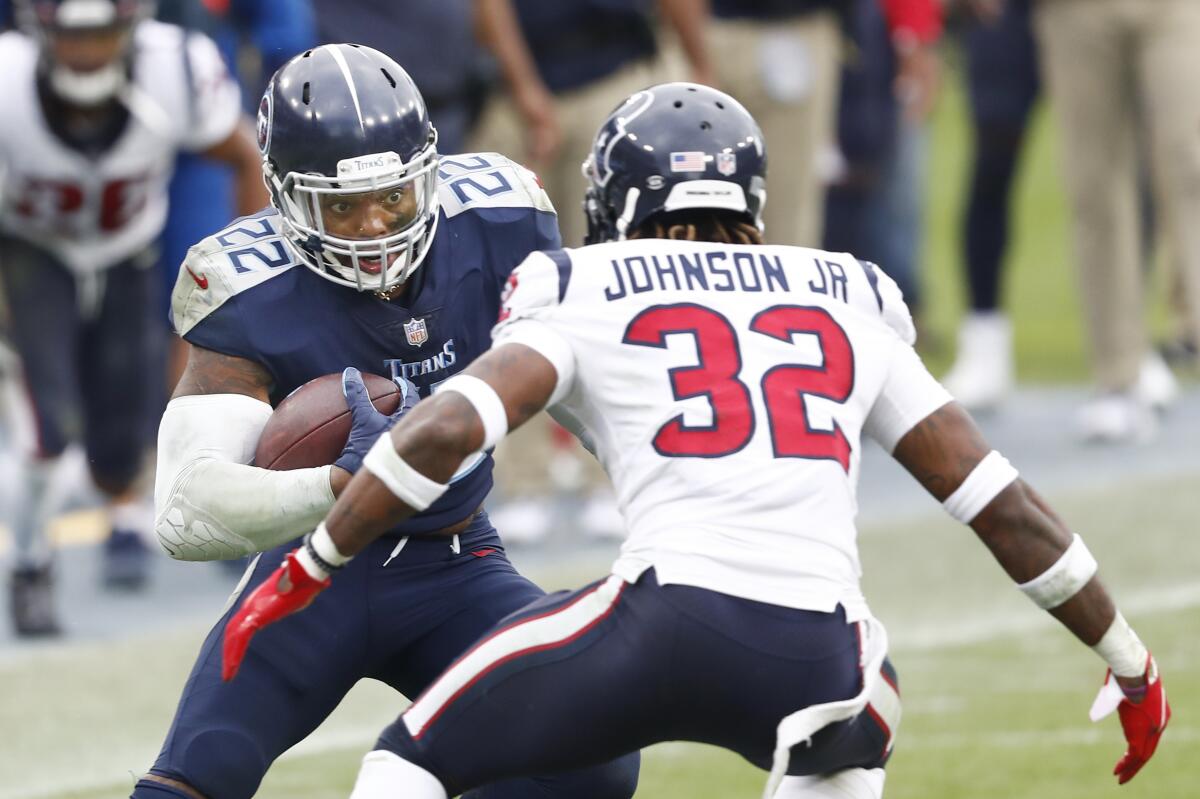 Tennessee Titans running back Derrick Henry carries the ball in front of Houston Texans cornerback Lonnie Johnson.