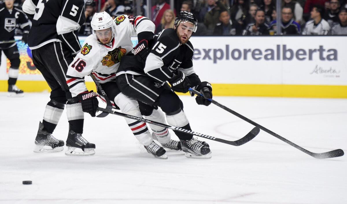 Kings center Andy Andreoff and Blackhawks center Marcus Kruger battle for the puck during the first half of their game Saturday.