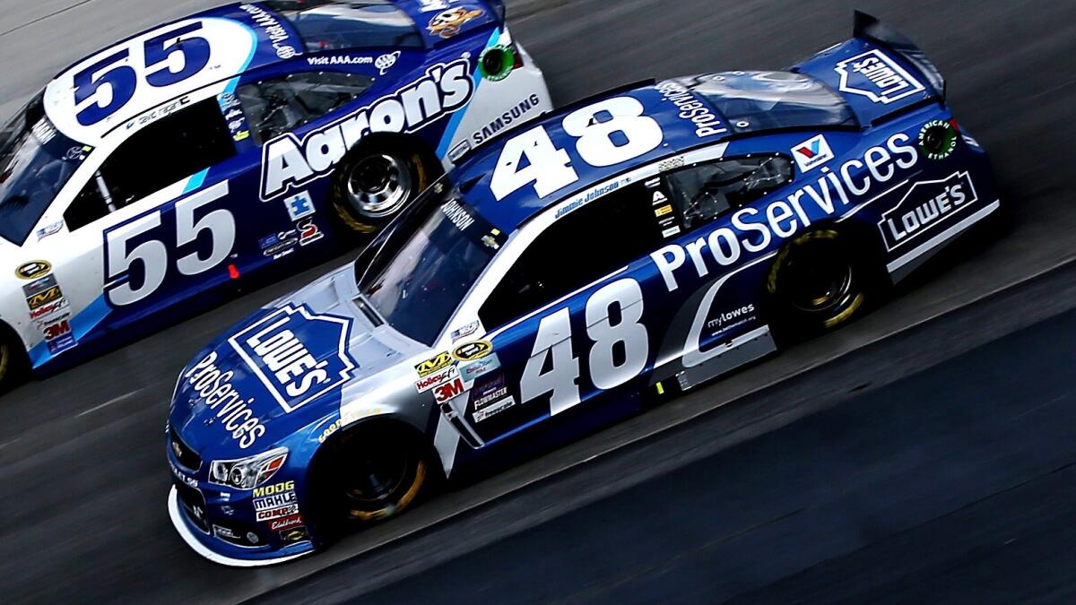 Jimmie Johnson races on the inside of David Ragan during Sunday's NASCAR Sprint Cup Series race at Dover International Speedway.