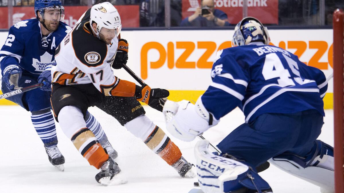 Toronto Maple Leafs goalie Jonathan Bernier, right, stops a shot by Ducks center Ryan Kesler, middle, in front of defenseman Stephane Robidas during the first period of Tuesday's game.