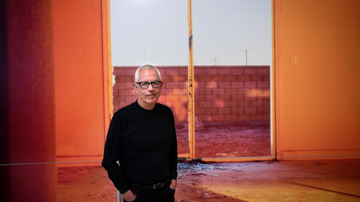 Anthony Hernandez stands before a mural-sized print of his image "Discarded #50" at SFMOMA.