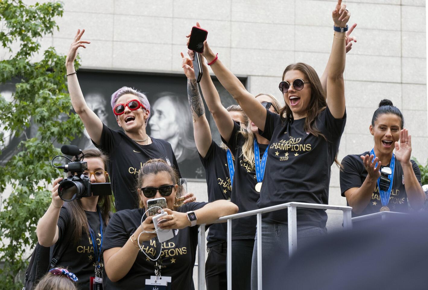 Members of the U.S. women's soccer team, including Megan Rapinoe, rear left, and Alex Morgan, right foreground, stand on a float before being honored with a ticker tape parade along the Canyon of Heroes in New York.