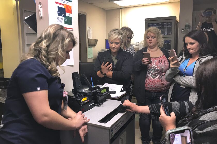 WILLIAMSON, WVA--Williamson Memorial Hospital staff huddle in the nurse's station to receive a ceremonial last call from the emergency dispatcher. (Jenny Jarvie / Los Angeles Times)