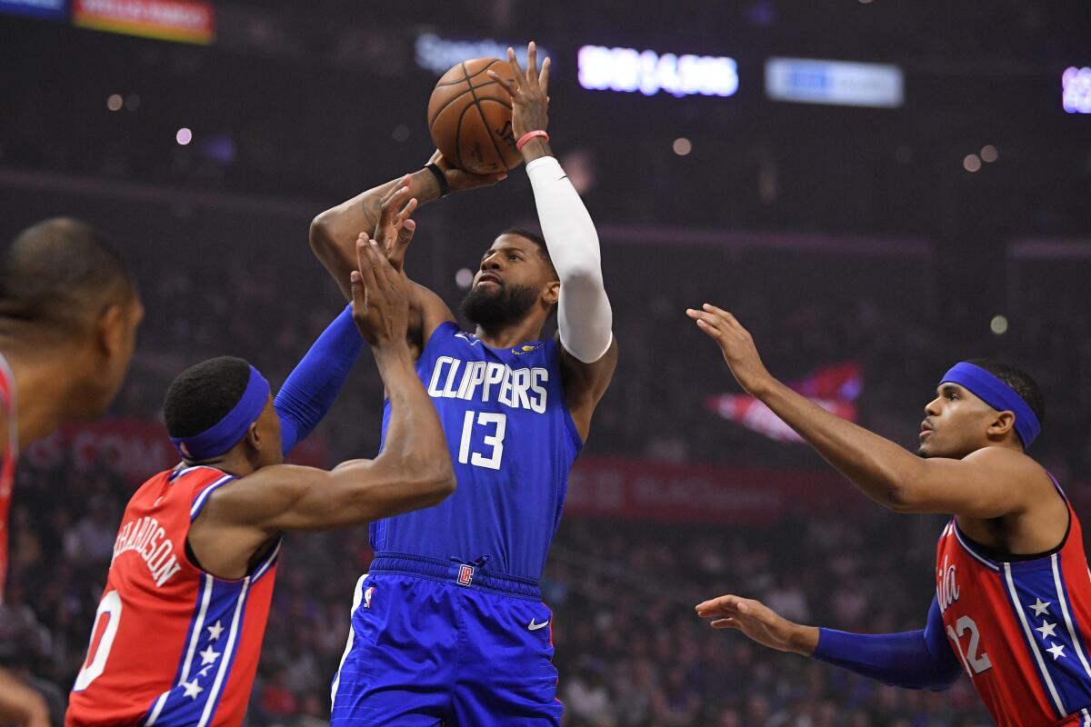 Clippers guard Paul George, center, shoots over Philadelphia 76ers guard Josh Richardson, left, and forward Tobias Harris during the Clippers' win Sunday.