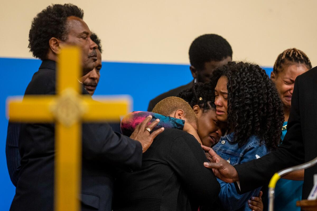  Tiffany Whitfield, left, and Lauren Gibson, right, comforts Laurell Robertson