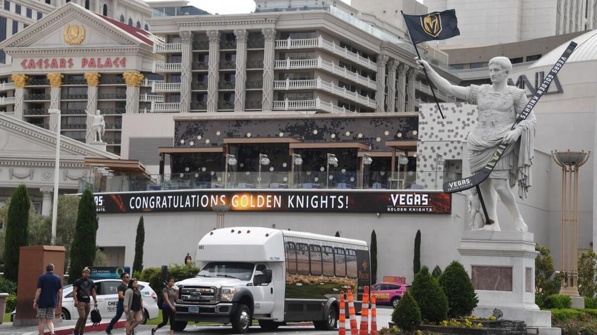 A statue in front of Caesars Palace displays an oversized Vegas Golden Knights hockey stick and a flag with the team's logo after the team's victory in the NHL Stanley Cup Playoffs on Monday.