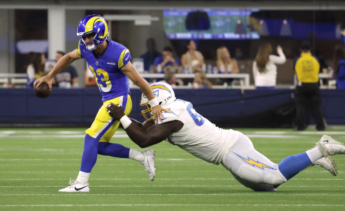 Rams quarterback Stetson Bennett is sacked by Chargers defensive lineman CJ Okoye for a 16-yard loss in the preseason.