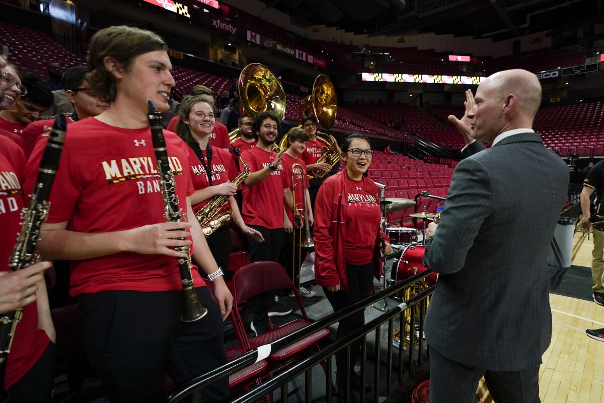 Kevin Willard, right, talks to members of the University of Maryland band after a news conference announcing Willard as coach of the Maryland men's NCAA college basketball team Tuesday, March 22, 2022, in College Park, Md. (AP Photo/Julio Cortez)