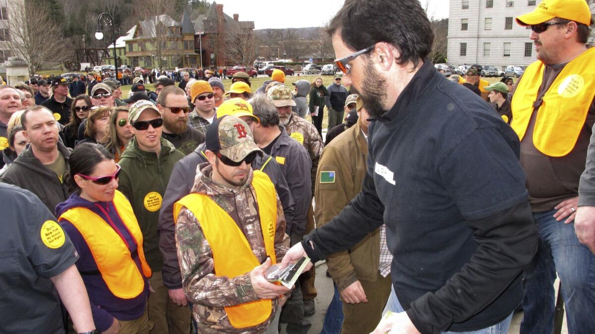 Gun rights advocates hand out 30-round magazines at an event outside the Vermont Statehouse in Montpelier in March to protest gun-control laws. The measures, including a "red flag" law, were signed into law.