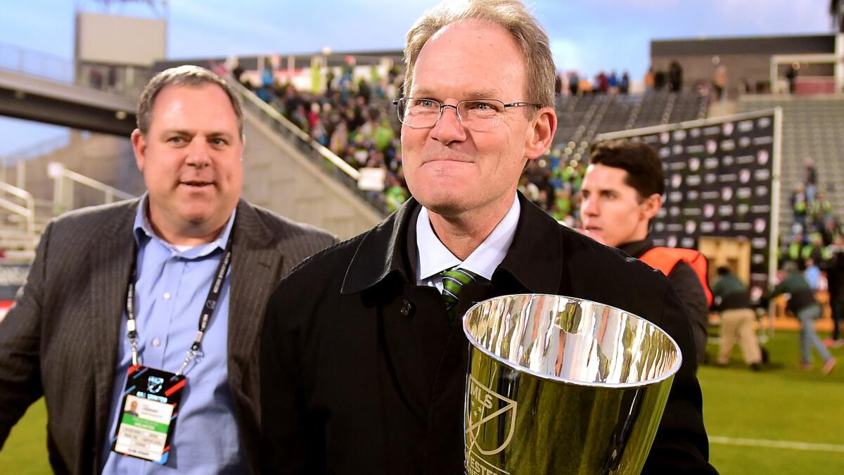 Sounders Coach Brian Schmetzer leaves the field in Commerce, Colo., with the Western Conference champions trophy.
