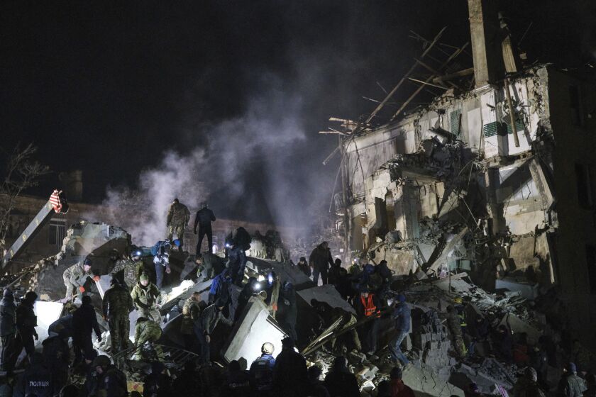 Trabajadores de emergencias y vecinos retiran escombros tras el impacto de un cohete ruso contra un edificio de apartamentos en Kramatorsk, Ucrania, el jueves 2 de febrero de 2023. (AP Foto/Yevgen Honcharenko)