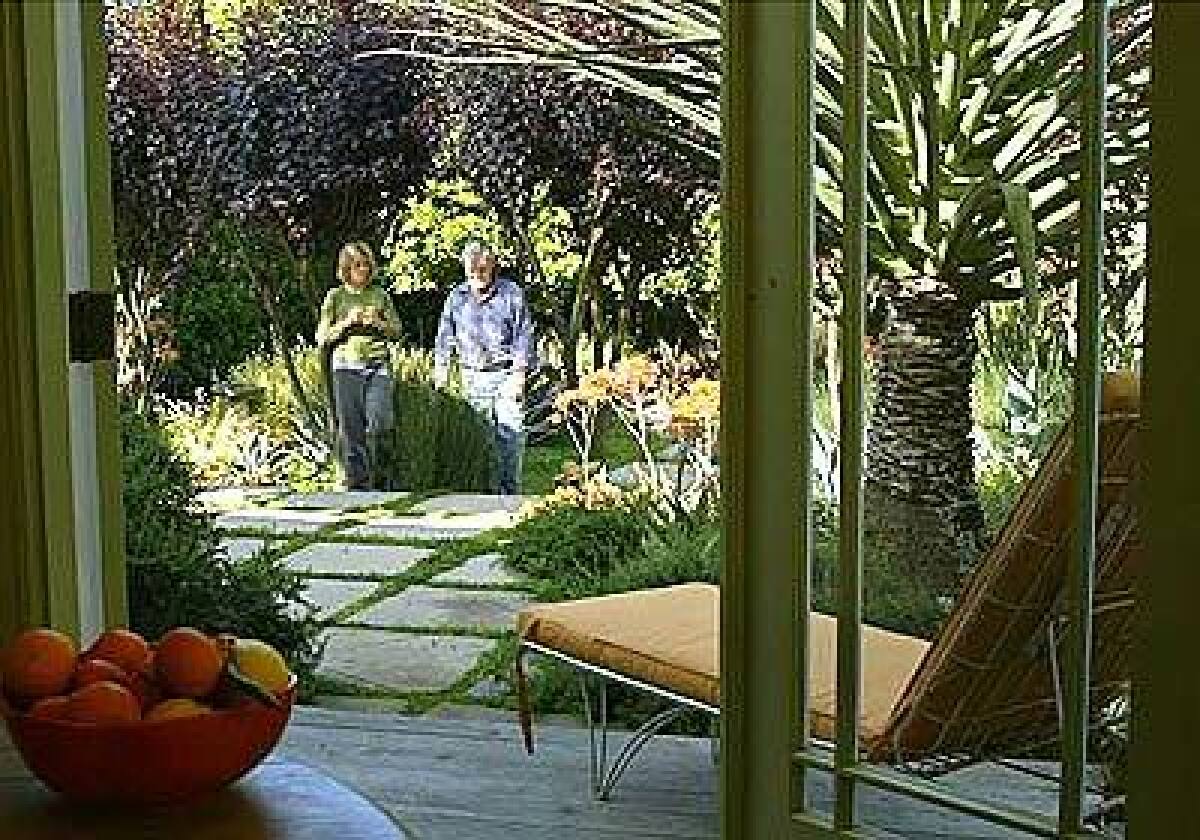 Homeowner Jan Brilliot, left, strolls through her garden with the landscape designer Jay Griffith. This garden will be on the Venice tour, which the two co-founded 10 years ago.