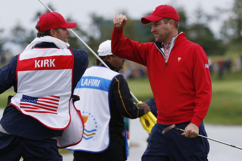 United States' Chris Kirk celebrates with his caddie GW Gable after sinking a putt on the 18th hole to defeat International team player Anirban Lahiri of India at the Presidents Cup.