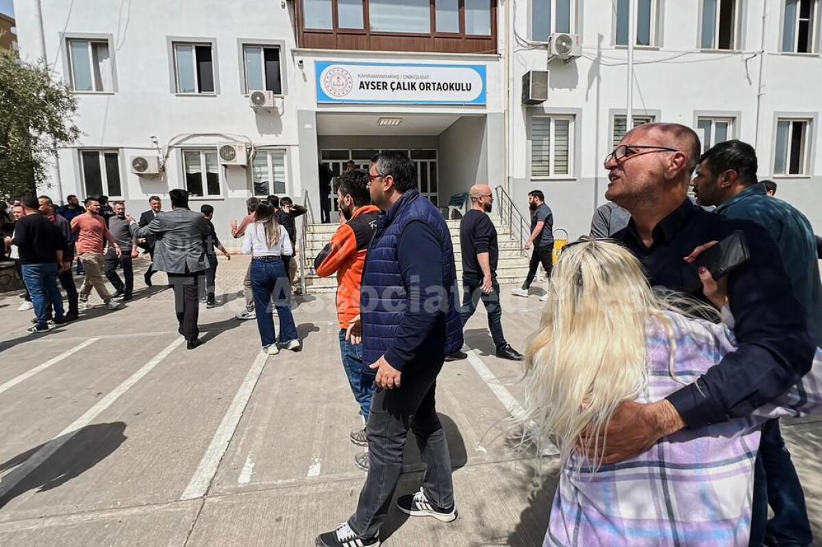 People stand at the courtyard of a secondary school where an assailant opened fire, in Kahramanmaras, Turkey