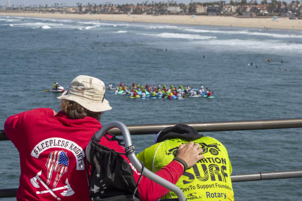 Air Force veteran Michael Muller, left, and Ramesh Hatasingh share a moment while others paddle out.
