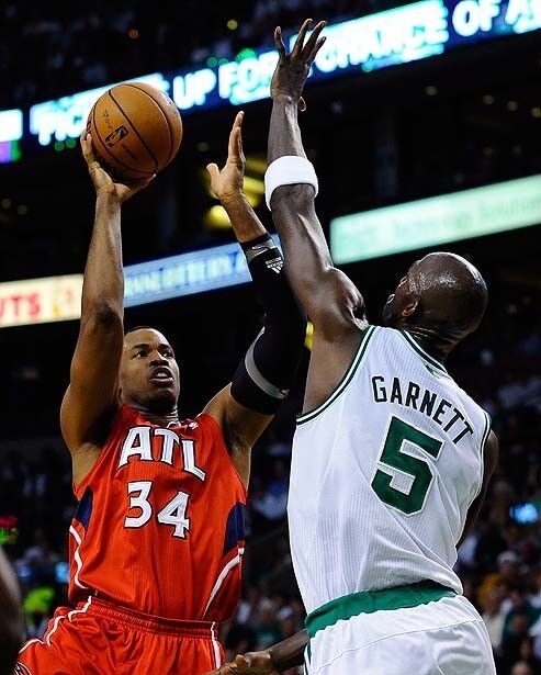 Jason Collins, left, then of the Atlanta Hawks, shoots over Boston Celtics forward Kevin Garnett during a 2012 playoff game in Boston.