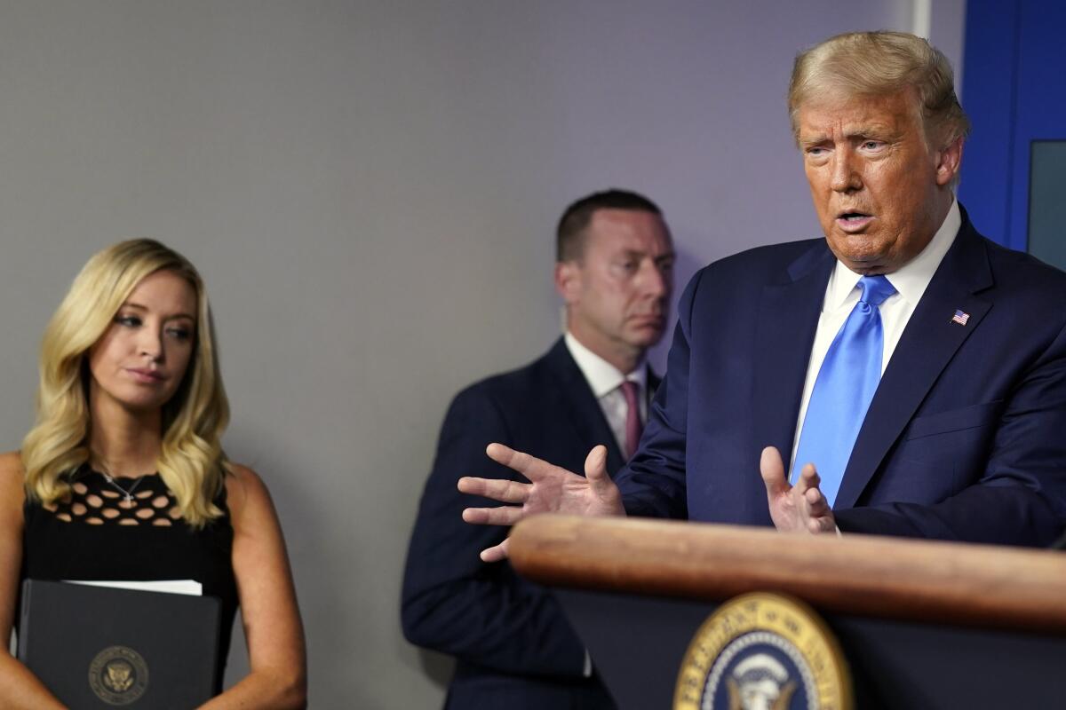 President Trump speaks at a news conference at the White House on Wednesday as Press Secretary Kayleigh McEnany listens.