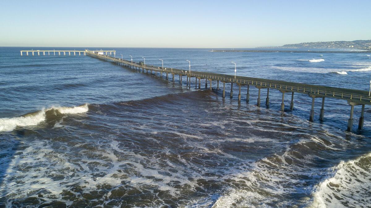 Waves roll under the Ocean Beach Pier in January 2020.