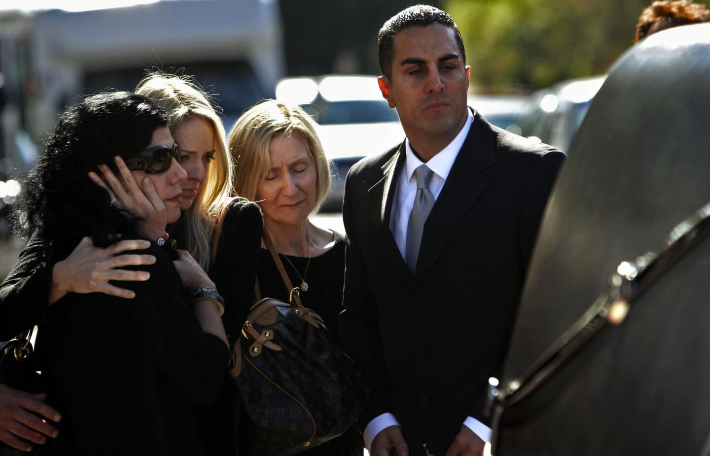 Mariann Gatto, left, Danielle Gatto, Isolde Gatto and California Assemblyman Mike Gatto look at the hearse carrying Joseph Gatto's casket at Our Mother of Good Counsel Catholic Church in Los Feliz.