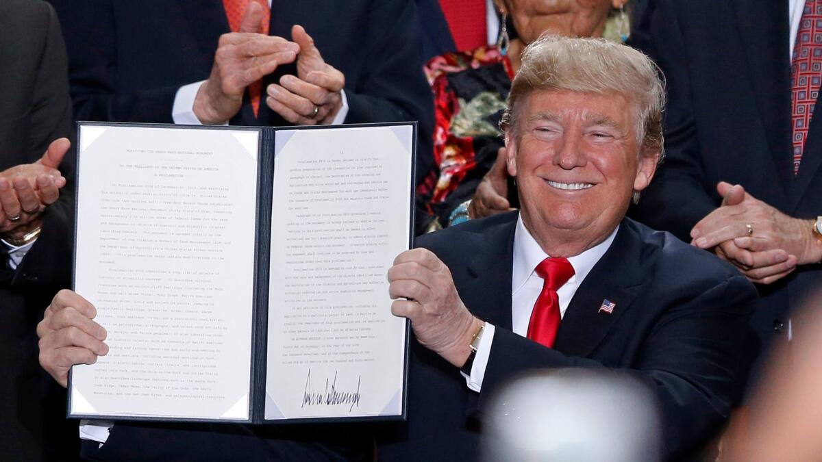 President Trump holds up a signed proclamation to shrink the size of Bears Ears and Grand Staircase-Escalante national monuments at Utah's state Capitol in Salt Lake City on Dec. 4, 2017.