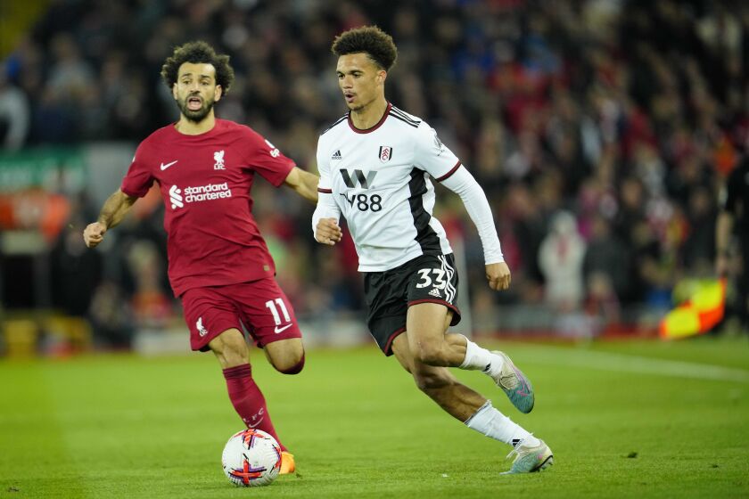 Liverpool's Mohamed Salah, left, challenges for the ball with Fulham's Antonee Robinson during the English Premier League soccer match between Liverpool and Fulham, at Anfield Stadium, Liverpool, England, Wednesday, May 3, 2023. (AP Photo/Jon Super)