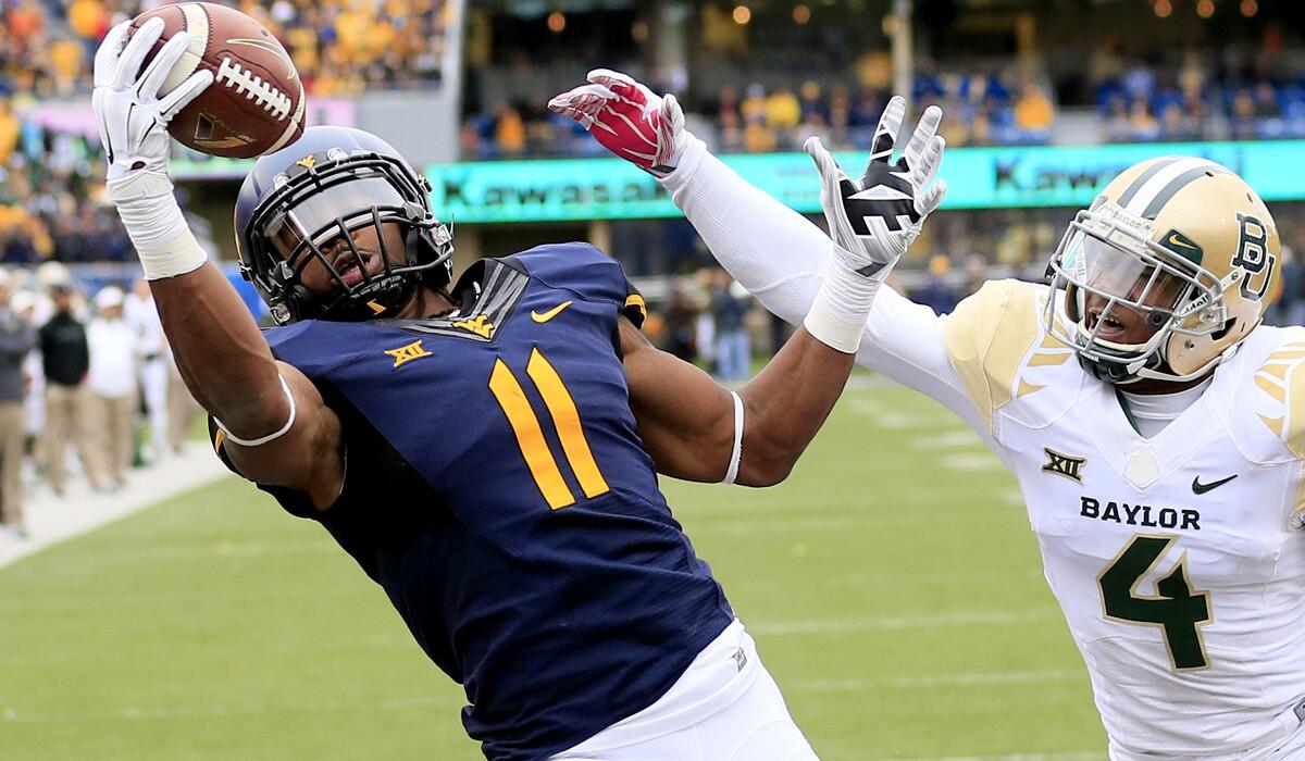 West Virginia receiver Kevin White (11) makes a one-handed touchdown catch over Baylor defensive back Xavien Howard (4) in the fourth quarter Saturday afternoon.