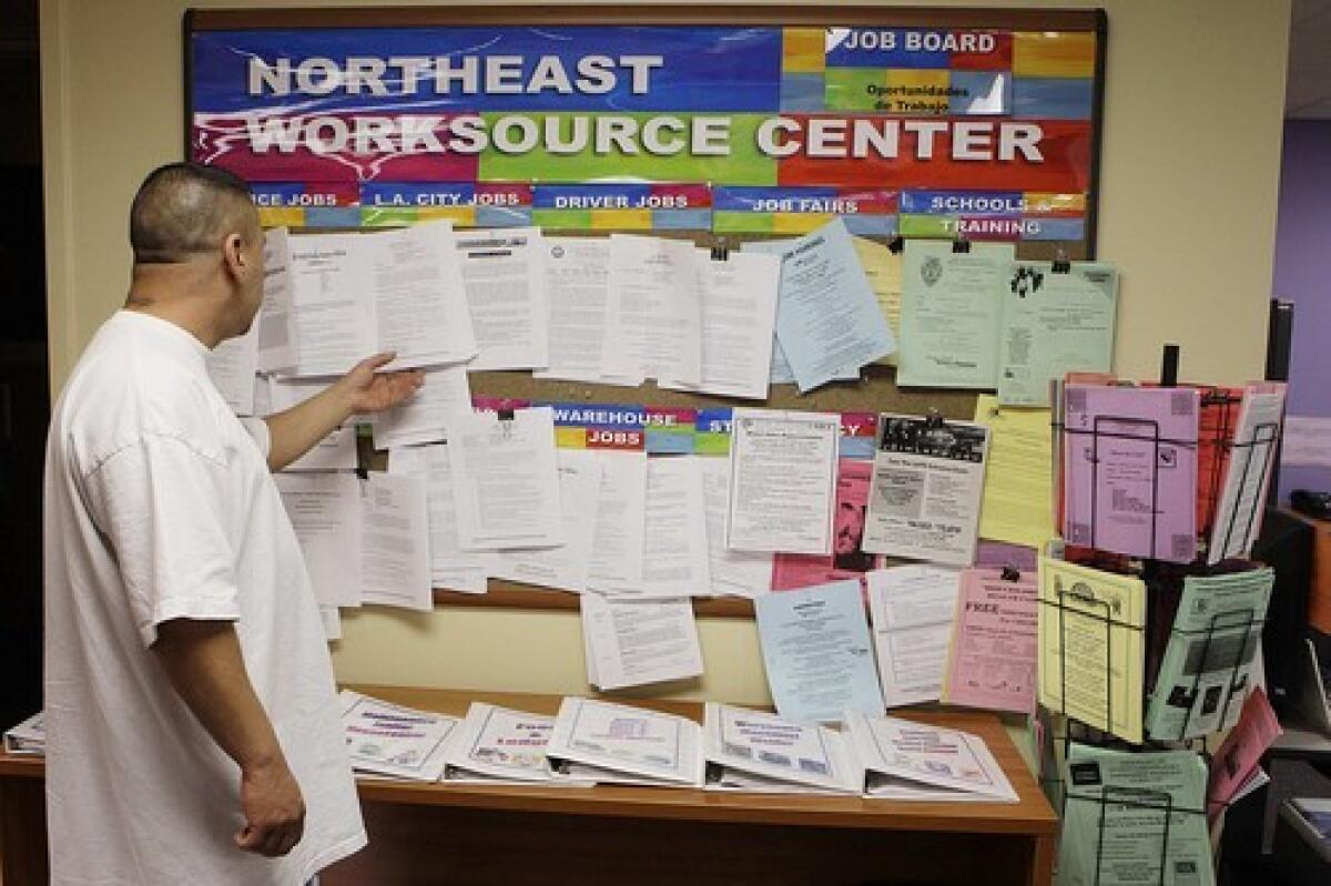 A man looks at job postings at the One-Stop Career Center in East Los Angeles. With jobless claims skyrocketing, Gov. Gavin Newsom said Friday the state is expanding its call center hours.