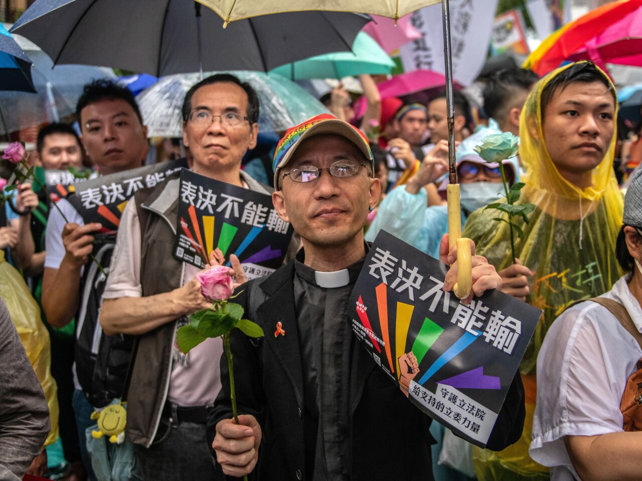 A priest waits with others outside Taiwan's parliament in Taipei awaiting a vote on legalizing same-sex marriage.
