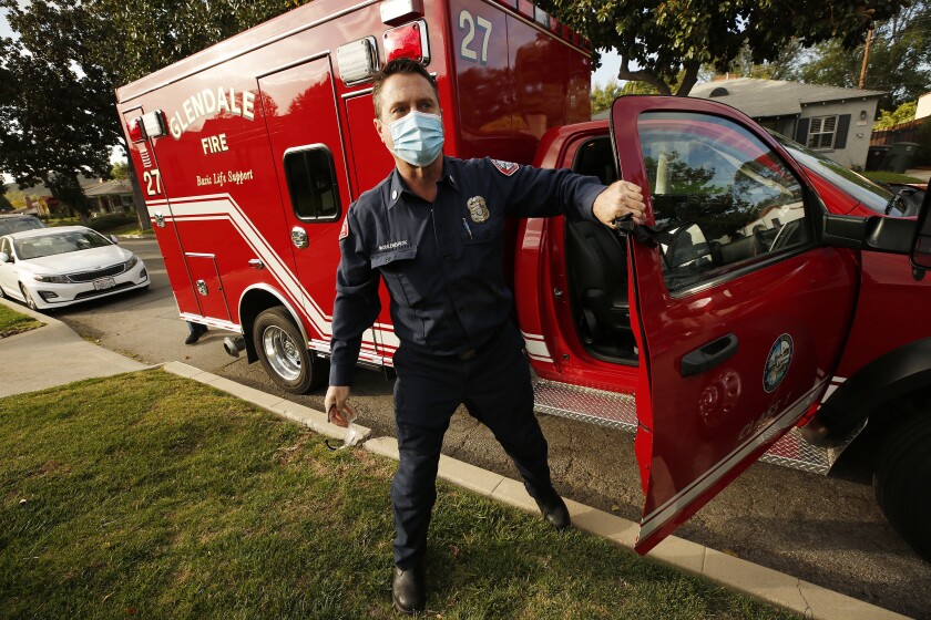 A firefighter-paramedic exits an ambulance