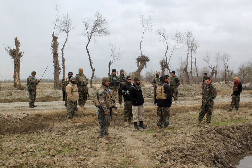 Afghan security forces stand by a road after an attack by the Taliban in Kunduz province.