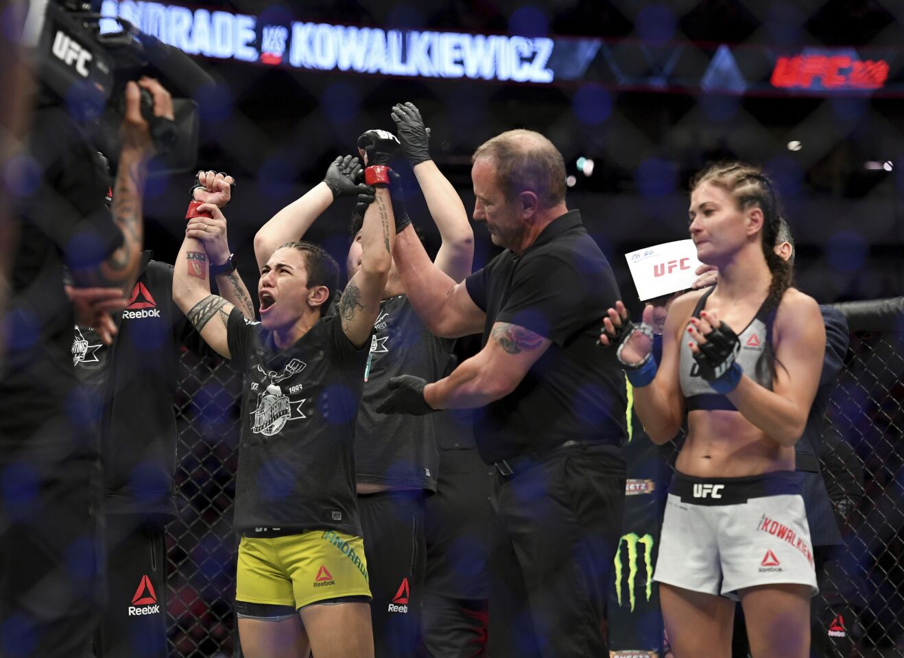 Jessica Andrade, left, is acknowledged as the winner after knocking out Karolina Kowalkiewicz, right, in their strawweight title mixed martial arts bout at UFC 228 on Saturday, Sept. 8, 2018, in Dallas. (AP Photo/Jeffrey McWhorter)