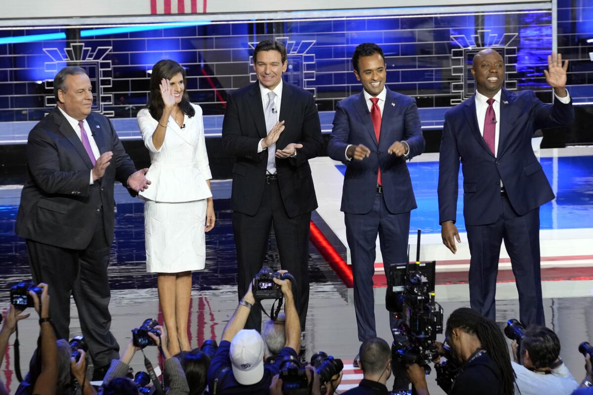 Chris Christie, Nikki Haley, Ron DeSantis, Vivek Ramaswamy and Tim Scott standing onstage, clapping and waving to a crowd