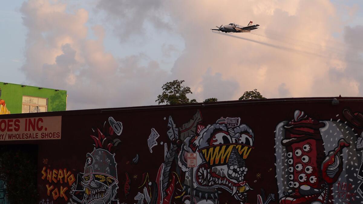 A plane sprays insecticide over Miami's Wynwood neighborhood to reduce the number of mosquitoes.