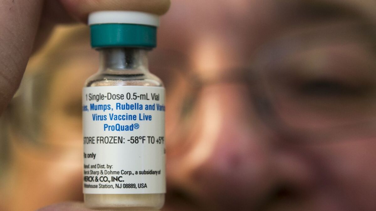 A pediatrician holds a dose of the measles-mumps-rubella (MMR) vaccine at his practice in Northridge, Calif., in 2015.