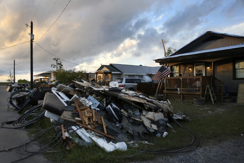 FILE - Debris and electrical wires are piled up in a front yard in Chauvin, La., on Sept. 27, 2021. In the aftermath of Hurricane Ida, Louisiana lawmakers said Wednesday, Dec. 1, 2021 they are seeing slow responses to damage claims, constant switch-ups of insurance adjusters assessing the destruction and low payment offers forcing people unnecessarily into litigation to get a fair deal. (AP Photo/Jessie Wardarski)