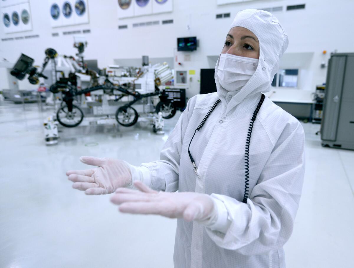 Jessica Samuels, Jet Propulsion Laboratory's Mars 2020 lead flight system systems engineer, talks about NASA's next spacecraft headed to the Red Planet at the Spacecraft Assembly Facility clean room. The rover was constructed in the clean room and is undergoing final testing. The rover, its rocket-powered descent stage and the mission's cruise stage was on display.